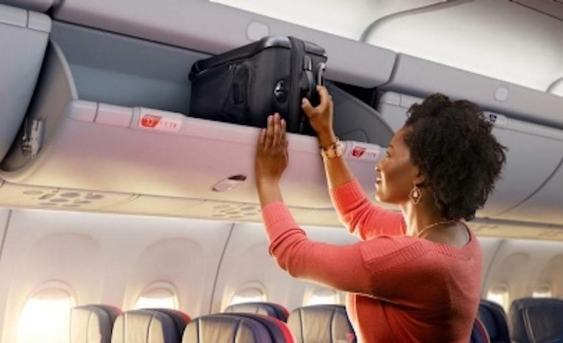 Woman Hoisting Suitcase Into Overhead Bin Hopes Everyone on Plane Marveling at Her Strength